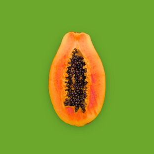 picture of a papaya split in half with a green plain background