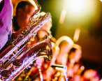 Picture of multiple people playing the saxaphone lined up in a row.